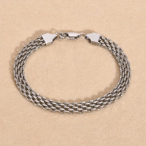 Detail of silver stainless steel mesh chain bracelet with a triple-row flat weave design