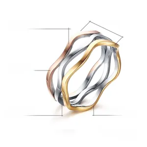 Detail view showing three-tone wavy stainless steel rings in gold, silver, and rose gold