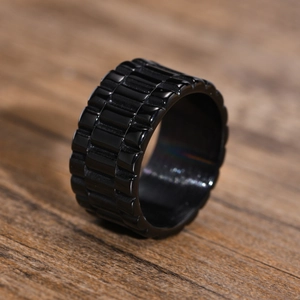 Vue macro d'une bague large noire en acier inoxydable avec motif d'engrenage