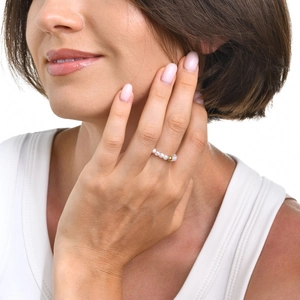 Gros plan d'une bague perlée en or et perles blanches montrant des détails fins