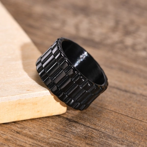 Macro d'une bague industrielle en acier inoxydable noir avec texture d'engrenage sur bois