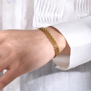 Elegant gold mesh chain bracelet in stainless steel shown worn on a female wrist