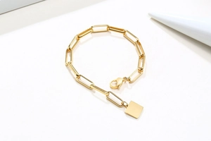 Vue détaillée du bracelet chaîne trombone en or 18K avec un pendentif carré épuré