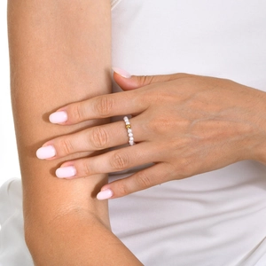 Bague minimaliste en perles et bille dorée 18k portée à l'index par le mannequin