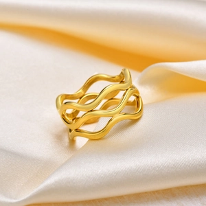 Macro detail of multi-layer golden wave ring on elegant silk fabric background
