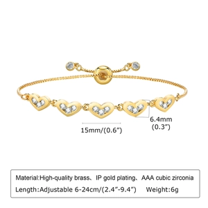 Detail of adjustable golden brass bracelet with heart charms and cubic zirconia