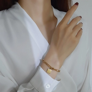 Détail du bracelet en acier inoxydable doré 18K avec maille trombone et pendentif carré