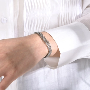 Detailed close-up of a multi-layer silver stainless steel mesh chain bracelet on a wrist