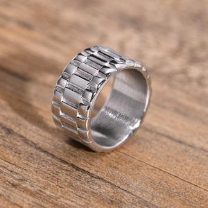 Gros plan sur bague large en acier argenté avec texture d'engrenage industriel