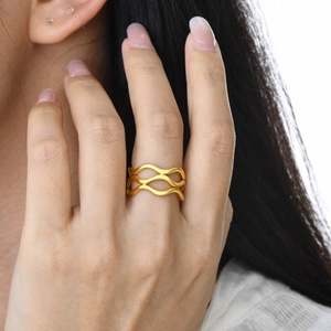 Close-up of a stacked triple-layer gold wave ring with an elegant hollow design