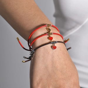 Three-piece layered adjustable red cord bracelets with gold dolphin tail and heart charms