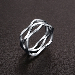 Macro detail of silver stainless steel multi-layer wave ring on dark leather