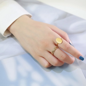 Polished gold oval signet ring and braided rope band set worn by a female model