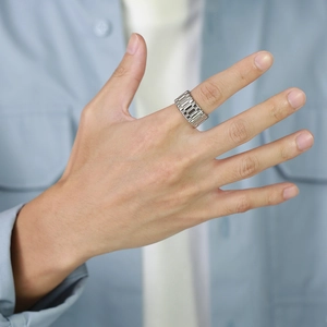 Gros plan d'une bague large en acier inoxydable argenté style bracelet de montre