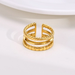 Macro detail of gold-plated triple-layer open ring featuring twisted and rectangular textures