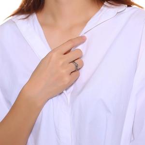 Detail of silver multi-layer wavy stainless steel ring worn on model's finger