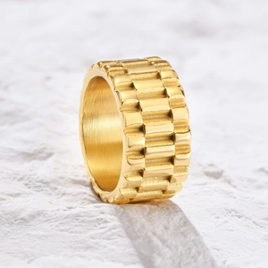 Détail de la bague dorée en acier inoxydable avec texture de bracelet sur pierre