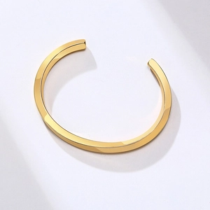 Close-up of gold stainless steel open cuff bracelet with polished square-edge design