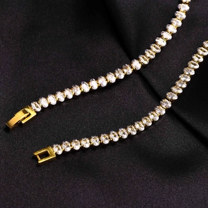 Detail eines goldenen Tennisarmbands mit weißen ovalen Zirkonia und Kastenverschluss