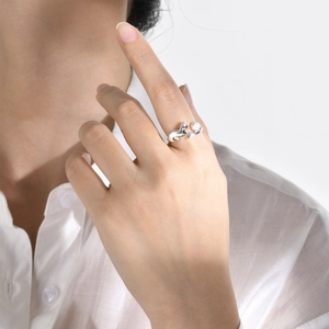Detail of silver cat ring with moonstone on hand, showing elegant design and minimalist style