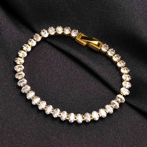Makro-Detail von Gold-Tennisarmband mit ovalen Zirkonia auf schwarzem Seidenhintergrund