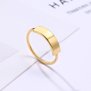 Macro shot of minimalist gold titanium steel ring with rectangular plate for engraving