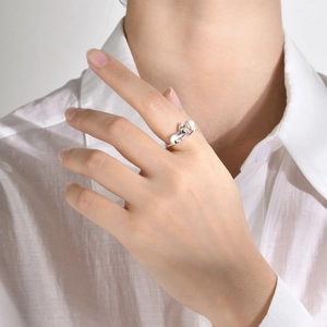 Detail of adjustable silver cat ring featuring a moonstone bead on woman's finger