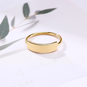 Macro detail of minimalist gold titanium steel ring with a polished curved rectangular plate