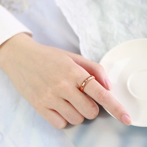 Close-up of 4mm rose gold tungsten ring with a single zircon inlay on a model's finger