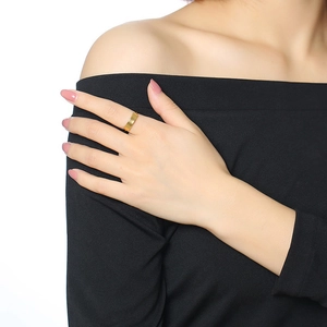 Close-up of minimalist gold titanium wide band ring worn on index finger with mirror finish