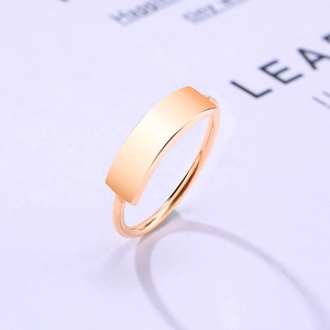 Macro detail of minimalist rose gold curved plate ring on elegant paper background