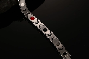 Macro view of stainless steel magnetic therapy bracelet with inset zircon and energy stones