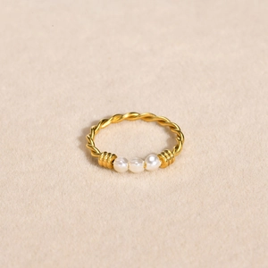 Détail macro de la bague torsadée plaquée or 18 carats avec trois perles blanches fines