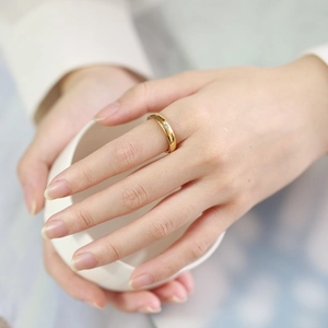 Minimalist 4mm rose gold tungsten ring with single cubic zirconia on a female hand