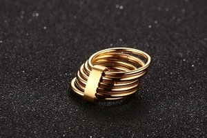 Macro shot of gold multi-layer ring with polished bands and brushed metal bar detail