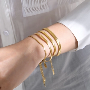 Set of four gold-plated flat snake bone bracelets featuring adjustable chains and pendants