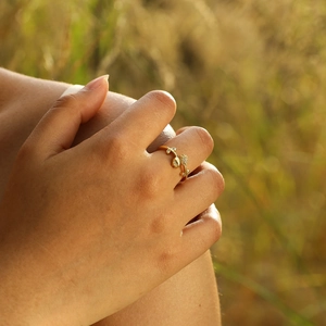 Detailed view of adjustable 18K gold tulip ring featuring leaf motifs and crystal zircons