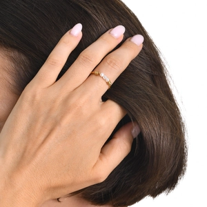 Détail d'une bague torsadée plaquée or 18 carats avec trois petites perles lustrées