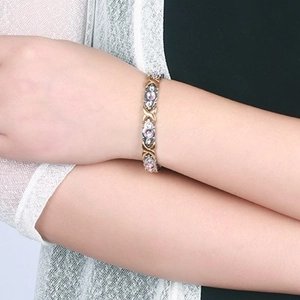 Titanium magnetic bracelet for women featuring gold X-links and pink zircon inlays