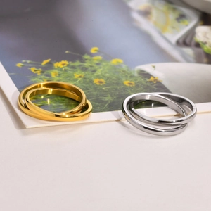 Detail of three-interlocking bands in gold and silver finish with high-polish texture