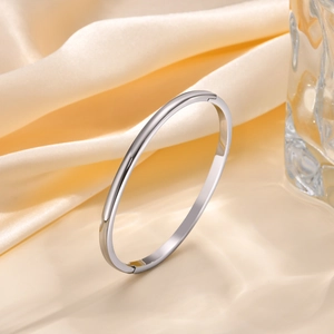 Detailed close-up of a silver stainless steel oval bangle with invisible hinge clasp