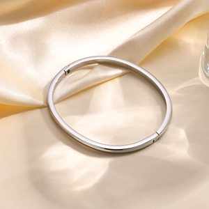 Polished silver stainless steel open bangle on champagne silk with water ripples