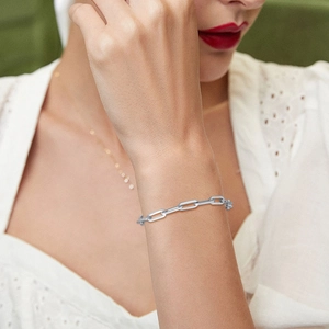 Detail view of minimalist silver stainless steel chain bracelet on a model wrist