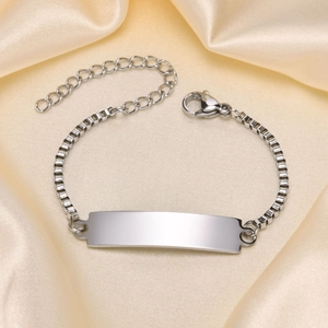 Detailed macro view of a polished stainless steel box chain ID bracelet with lobster clasp