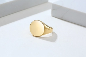 Close-up of a minimalist 18K gold-plated stainless steel signet ring with a mirror finish