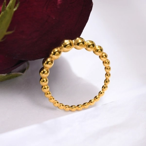 Detailed close-up of golden beaded stainless steel ring with red rose on white background