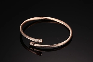 Detail of rose gold twisted cable open cuff bracelet with spherical textured ends