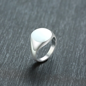 Macro shot of polished silver signet ring top with reflective finish on dark background