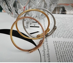 Detailed view of three-color twisted cable cuff bracelets in gold silver and rose gold