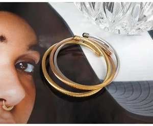 Detailed macro view of triple-tone titanium steel cable twist bangle set in three colors